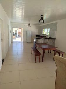 ein Wohnzimmer mit Tisch und Küche in der Unterkunft Casa na praia de Jatobá in Barra dos Coqueiros + 7 Fotos
