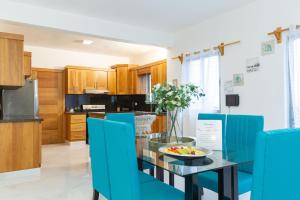 a kitchen with a glass table and blue chairs at Crown lll with Pool -3 Bedrooms close to Everything in Puerto Plata