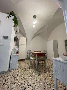 a room with a table and a kitchen with a refrigerator at The White Rose in Ceglie Messapica