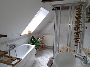 a bathroom with a tub and a shower and a sink at Dachstübchen mit 2 Zimmern in Boizenburg +14 photos