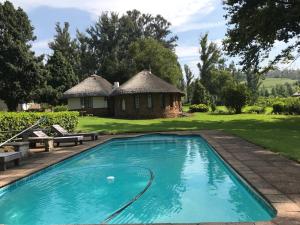 a swimming pool in front of a house at The Retreat Country Lodge in Romelcoh