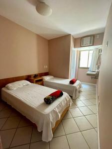 a hotel room with two beds and a window at Ocean Flat 401 in Vila Velha +22 photos
