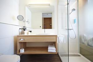 a bathroom with a sink and a shower at Hotel garni Oberdorfer Stuben in Obermaiselstein +64 photos