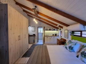 a large room with a bed and a kitchen at The Sculpture Yard in Gordonʼs Bay