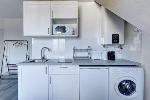 Una cocina blanca con fregadero y lavadora. en Bluestay 135 - Charming apartment, en Bagnolet