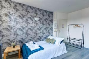 1 dormitorio con 1 cama y un mural en la pared en Bluestay 135 - Charming apartment, en Bagnolet