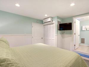 a bedroom with a bed and a flat screen tv at Tybee Tyme Lower in Tybee Island