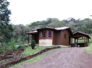 a small house in a field with a dirt road at Pousada Esperança in Osório +24 photos