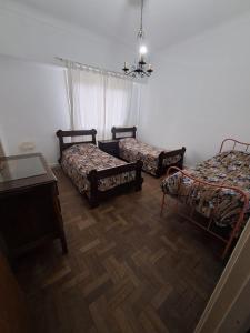a room with two beds and a table and a chandelier at Departamento Peatonal in Mar del Plata +3 photos