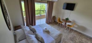 a living room with a couch and a table and a window at Hotel Barra da Ferrugem Eco Village in Garopaba