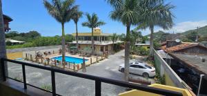 a view of a house with a pool and palm trees at Hotel Barra da Ferrugem Eco Village in Garopaba