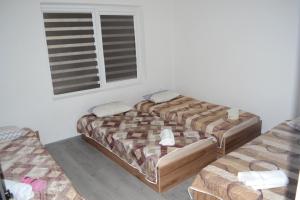 比托拉MIK apartman的有两张床和一扇窗户的卧室