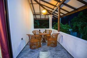 Un patio con sillas y una mesa en un balcón. en Sri Villa, en Dodanduwa