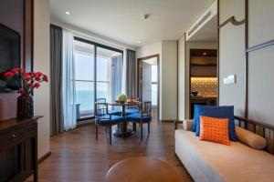 a living room with a couch and a table at Mandala Cham Bay Hotel Mũi Né in Mui Ne