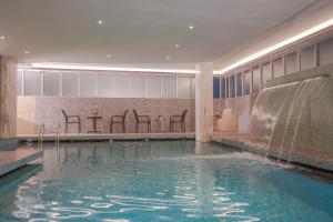 a swimming pool with a waterfall in a hotel at Royal Residence Dhaka in Dhaka