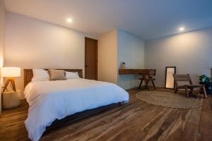 a bedroom with a large white bed and a desk at Bright 2BR Loft with Rooftop Pool in Best Tulum Downtown Location in Tulum