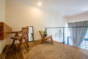 a room with chairs and a table and a window at Bright 2BR Loft with Rooftop Pool in Best Tulum Downtown Location in Tulum