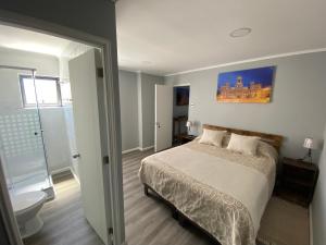 a bedroom with a bed and a bathroom with a tub at Hostal Madrid in Talca