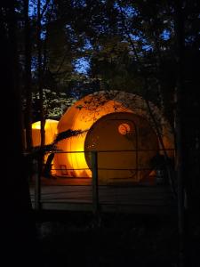 a large dome building in the woods at night at Estrella Glamping in Caraquet +32 photos