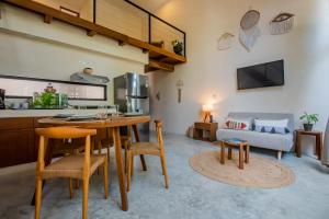 a living room with a table and chairs and a couch at Bright 2BR Loft with Rooftop Pool in Best Tulum Downtown Location in Tulum