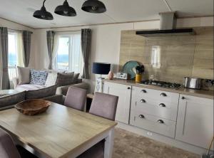 eine Küche und ein Wohnzimmer mit einem Tisch und einer Couch in der Unterkunft SeaView Sleeps 4to6 Pet friendly Parking in Wareham + 53 Fotos