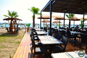 a restaurant on the beach with tables and umbrellas at Bungalow on the sea - Moriani beach in Santa-Lucia-di-Moriani