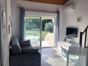 a living room with a couch and a sliding glass door at Bungalow on the sea - Moriani beach in Santa-Lucia-di-Moriani +12 photos