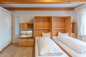 a bedroom with two beds and a tv at Direkt am Deich - Ferienwohnung Föhr im Gästehaus Am Badedeich in Dagebüll