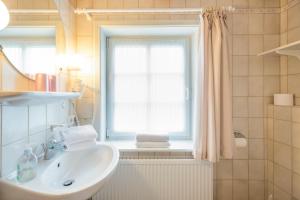 a bathroom with a sink and a window at Direkt am Deich - Ferienwohnung Föhr im Gästehaus Am Badedeich in Dagebüll