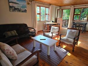 un soggiorno con un divano, sedie e un tavolo di Mitford Holiday Flats a Morgan's Bay