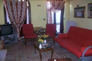 a living room with a red couch and red chairs at Tra... Monti E Vigne in La Morra