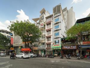 a busy city street with a tall building at Bong House close to train street at the Hanoi old quarter in Hanoi