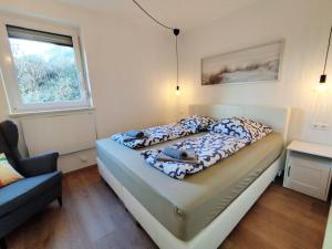 une chambre avec un lit, une chaise et une fenêtre dans l'établissement MOOKI Lake Apartment Ossiacher See&Gerlitzen, à Sattendorf