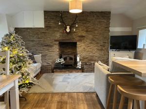 een woonkamer met een open haard en een kerstboom bij Winstitchen Cottage situated near the River Barle in Simonsbath
