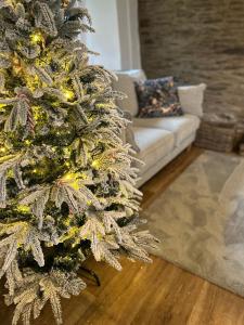 een kerstboom in een woonkamer met een bank bij Winstitchen Cottage situated near the River Barle in Simonsbath