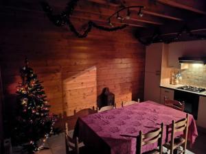 a dining room with a table and a christmas tree at chalet 2007 in Le Boulay