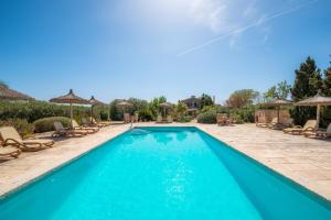a swimming pool with chairs and umbrellas at Sa Carrotja - Adults Only in Ses Salines