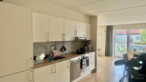 a kitchen with white cabinets and a sink at Oslo VIBE in Oslo