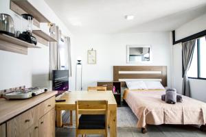 Habitación pequeña con cama, escritorio y mesa. en Lofts Tequisquiapan, en San Luis Potosí