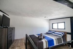 a bedroom with a bed with blue and white pillows at Lofts Tequisquiapan in San Luis Potosí