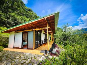 a house on a hill with a wooden deck at Cloudbridge Nature Reserve in Herradura