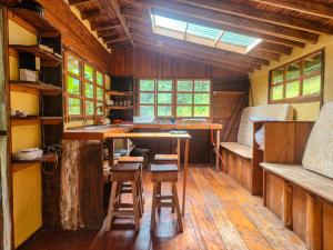 a room with a table and stools in a cabin at Cloudbridge Nature Reserve in Herradura