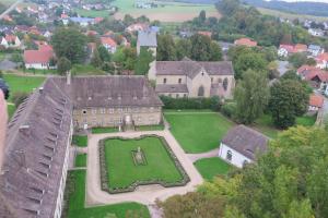 eine Luftansicht eines großen Hauses mit einem grünen Hof in der Unterkunft Hotel Schloß Gehrden in Gehrden