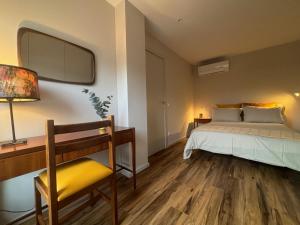 a bedroom with a bed and a desk and a chair at Three Little Birds in Guimarães