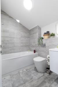 a white bathroom with a tub and a toilet at Open Mind Property - 2 Beds & FREE Parking in Brockhurst