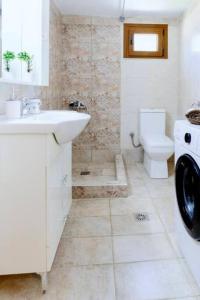 une salle de bain blanche avec un lavabo et des toilettes dans l'établissement Siena Cottage, à Nea Makri 16 autres photos