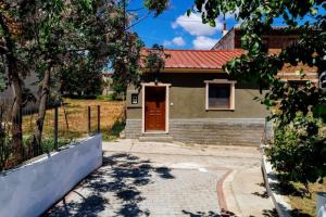 une maison avec une porte rouge et une allée en briques dans l'établissement Siena Cottage, à Nea Makri