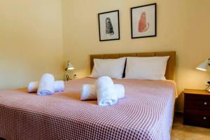 un lit avec deux animaux farcis au-dessus dans l'établissement Siena Cottage, à Nea Makri