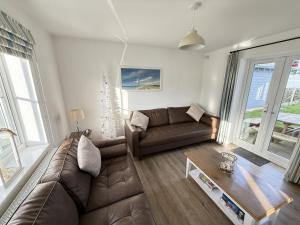 a living room with a couch and a table at New England Cottage - Part of the The Bay Filey Holiday Village with pool, gym and direct beach access, pub, restaurant, tennis and meadows walks in Filey