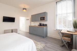 a bedroom with a bed and a desk and a kitchen at Host & Stay - Harbour Point in Ramsgate